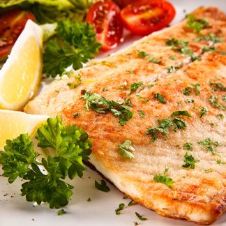 Flounder cooked with lemon wedge and parsley as garnish