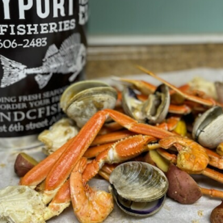 Boil can with a seafood feast spread out including snowcrab and clams