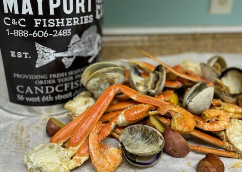 Boil can with a seafood feast spread out including snowcrab and clams
